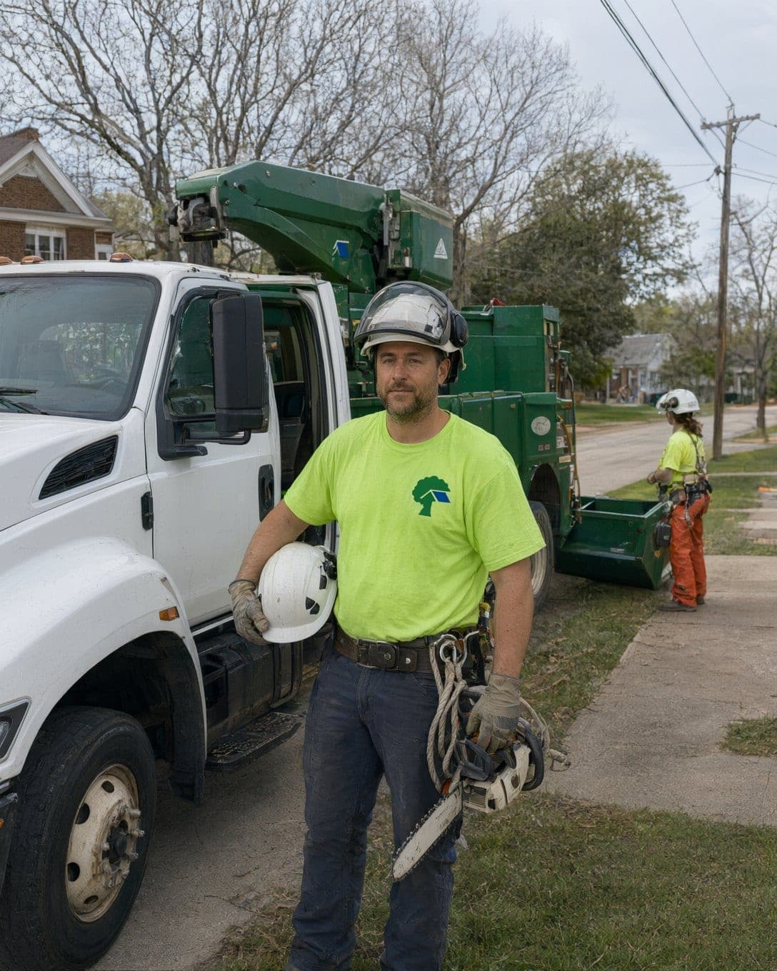 Kyle Brandt, owner, beside the bucket truck with his helmet under his arm